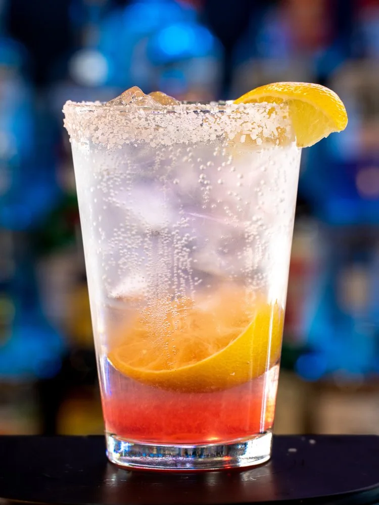 A Chilton in a tall glass with a salted rim and fresh lemon