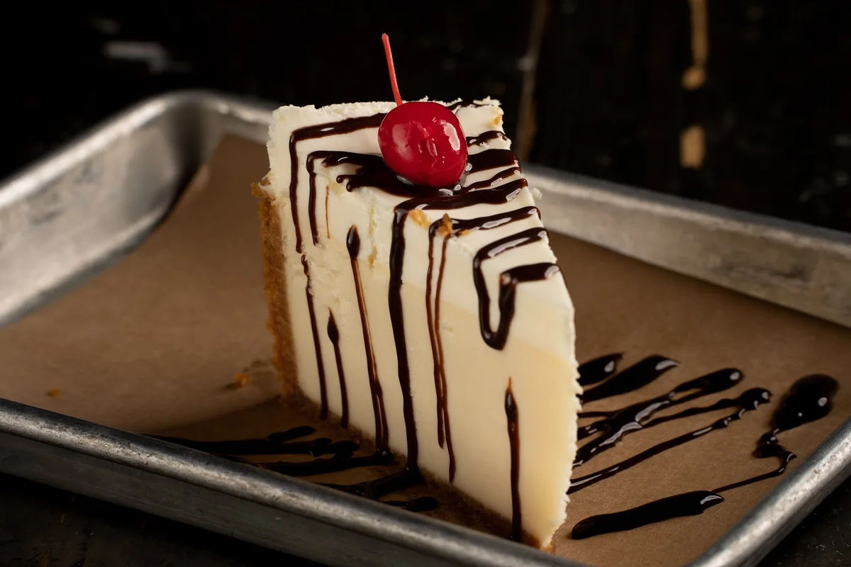 Royale cheesecake with chocolate drizzle and a cherry