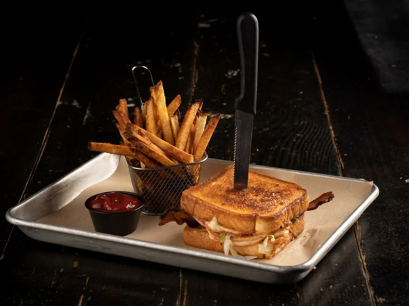Club sandwich on grilled Texas toast with a basket of fries