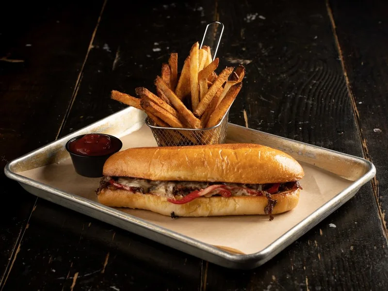 Philly cheesesteak on a hoagie bun with grilled peppers