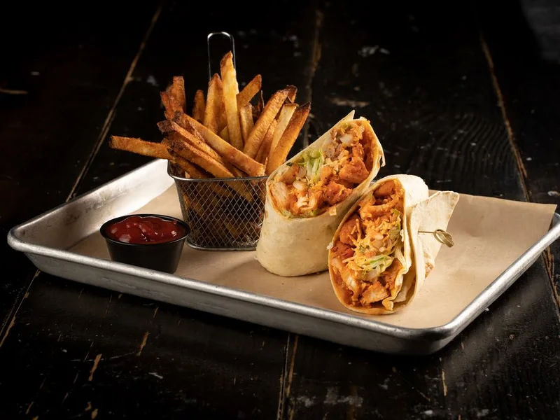 Buffalo wrap cut on the bias with a basket of fries